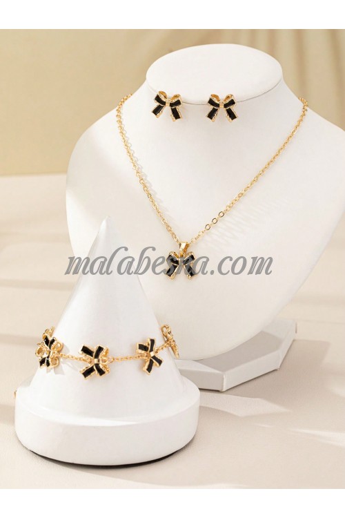 Golden set of earrings necklace and bracelet with black bow tie